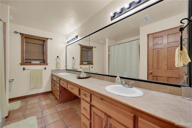 2724 Wildwood Dr, Weslaco, TX 78596 - bathroom with double vanity, baseboards, tile patterned flooring, and a shower with shower curtain