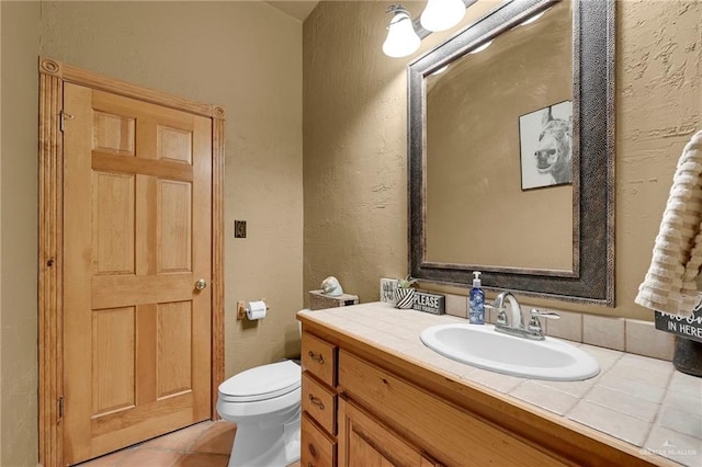 2724 Wildwood Dr, Weslaco, TX 78596 - bathroom featuring vanity, toilet, tile patterned flooring, and a textured wall