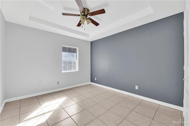 unfurnished room featuring light tile patterned floors, a raised ceiling, and ceiling fan