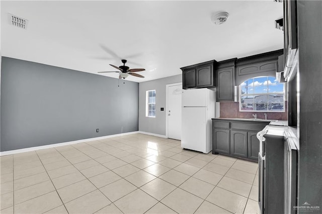 kitchen featuring light tile patterned floors, white refrigerator, plenty of natural light, and ceiling fan