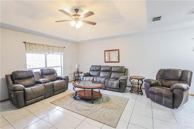 tiled living room featuring a tray ceiling and ceiling fan