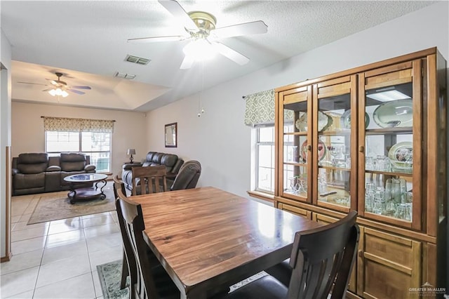 dining room with ceiling fan, light tile patterned flooring, and a textured ceiling