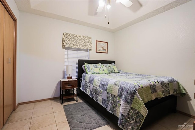 tiled bedroom with ceiling fan and a closet