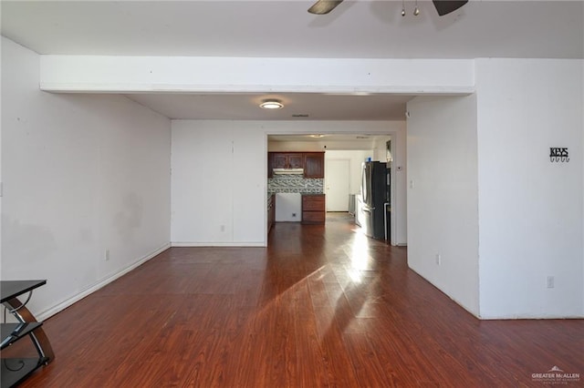 unfurnished room with dark wood-style floors, ceiling fan, and baseboards