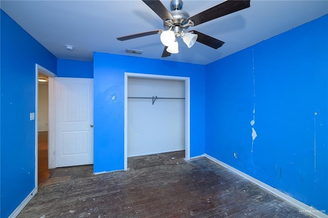 unfurnished bedroom featuring baseboards, visible vents, wood-type flooring, ceiling fan, and a closet