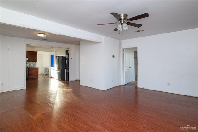 unfurnished room with dark wood-style floors, visible vents, and a ceiling fan