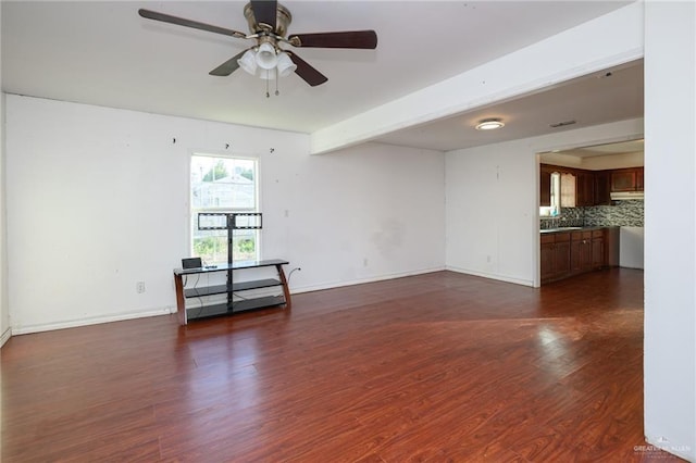 empty room with dark wood-style floors, baseboards, and a ceiling fan