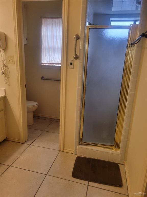 bathroom with walk in shower, vanity, toilet, and tile patterned flooring