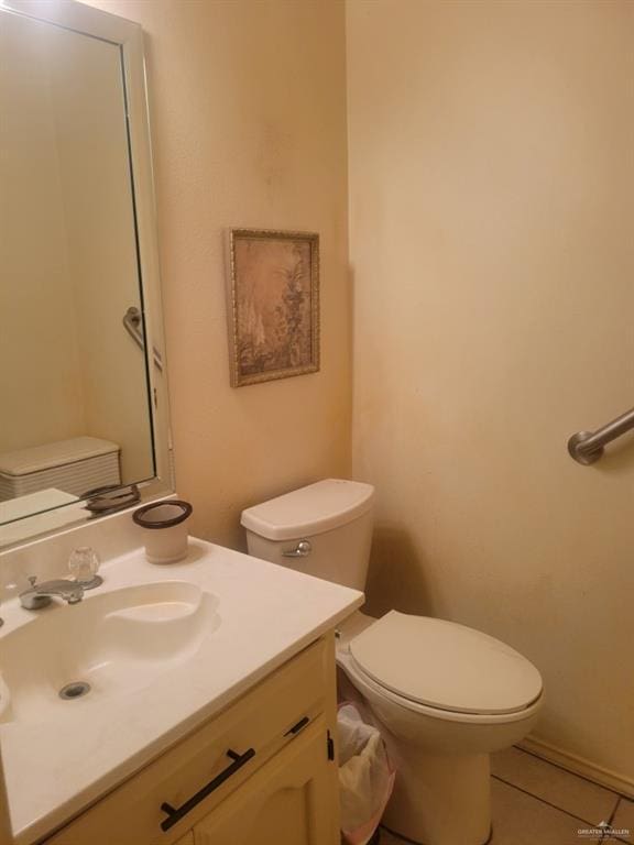 bathroom featuring tile patterned flooring, vanity, and toilet