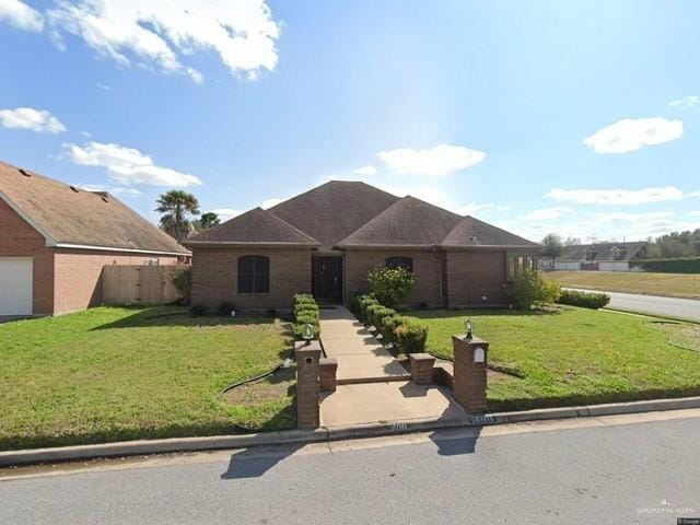 single story home featuring a front lawn