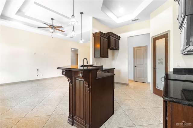 1704 Yellow Stone St, Edinburg, TX 78542 - kitchen featuring a tray ceiling, light tile patterned floors, dark brown cabinetry, and ceiling fan