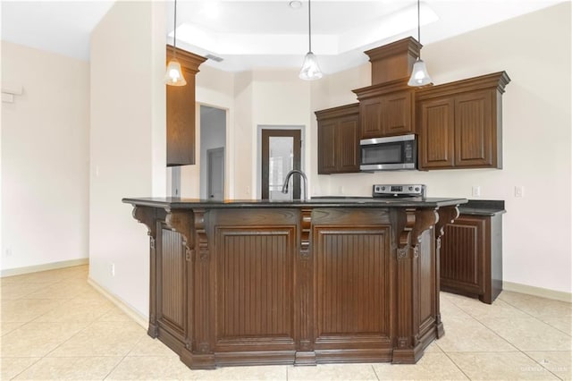 1704 Yellow Stone St, Edinburg, TX 78542 - kitchen featuring appliances with stainless steel finishes, dark countertops, light tile patterned floors, baseboards, and a breakfast bar area