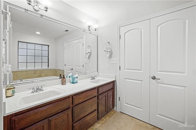 bathroom featuring tile patterned floors, a sink, and double vanity