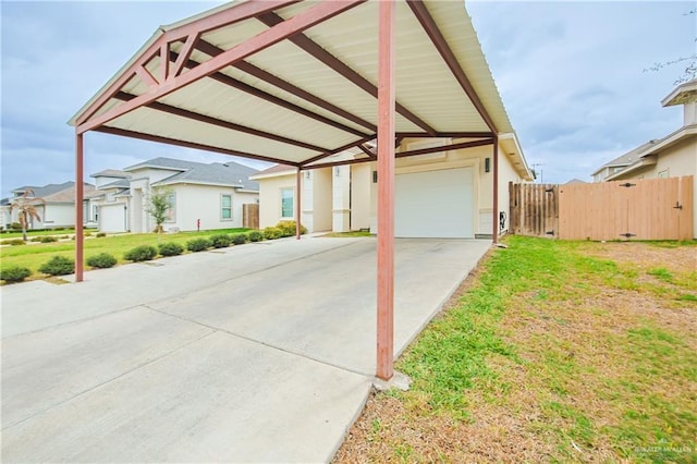 view of front of home with concrete driveway, a residential view, fence, a carport, and a front yard