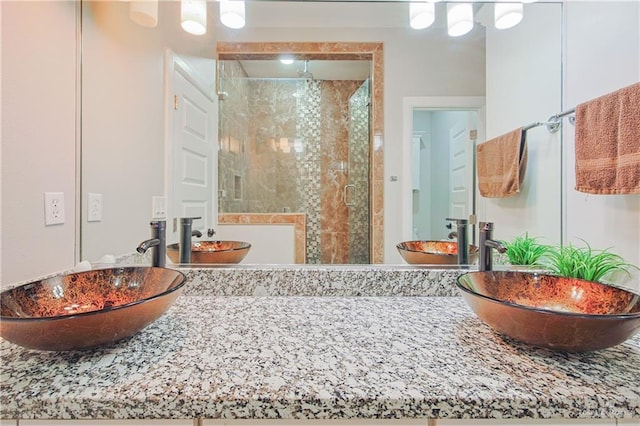 bathroom with a shower stall and a sink