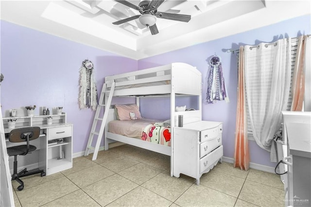 tiled bedroom featuring a tray ceiling and ceiling fan