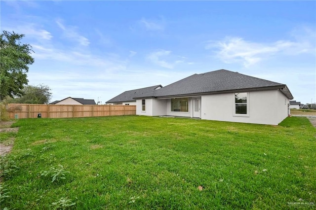 rear view of property with a yard