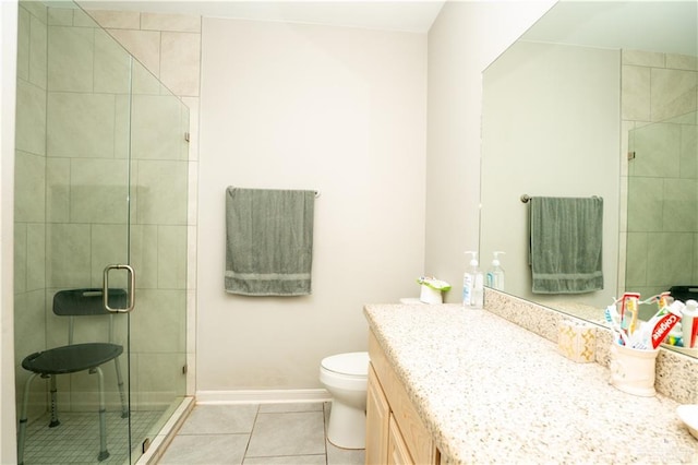 full bathroom featuring toilet, vanity, baseboards, a shower stall, and tile patterned floors