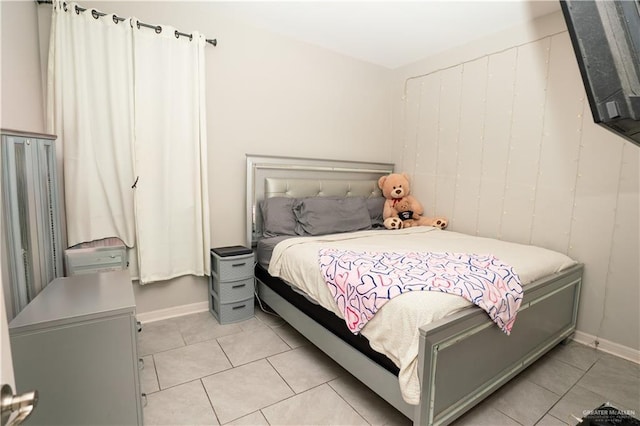 bedroom with light tile patterned floors and baseboards