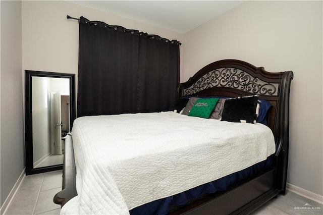 bedroom featuring tile patterned flooring and baseboards