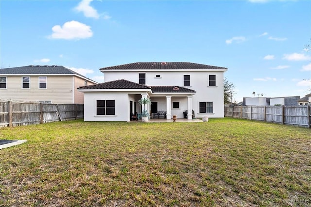 back of property featuring a lawn and a patio