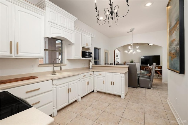 kitchen with sink, light tile patterned floors, decorative light fixtures, a notable chandelier, and white cabinets