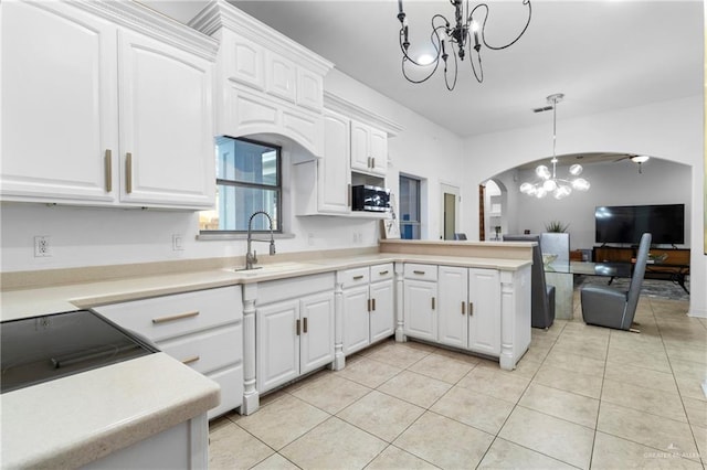 kitchen with white cabinetry, sink, and an inviting chandelier