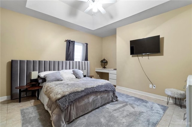 tiled bedroom featuring ceiling fan and a tray ceiling