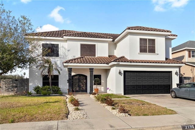 mediterranean / spanish home featuring a garage and a front yard