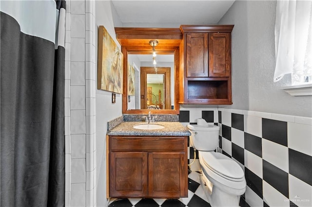 34349 Fm 732nd Hwy, San Benito, TX 78586 - full bath with vanity, a wainscoted wall, curtained shower, tile walls, and toilet