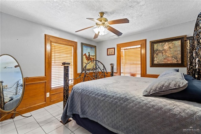 34349 Fm 732nd Hwy, San Benito, TX 78586 - bedroom with wainscoting, a textured ceiling, and a ceiling fan
