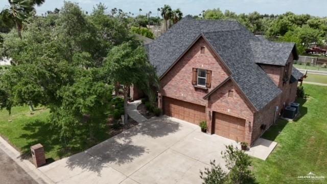 109 Palm Valley Cir, Harlingen, TX 78552 - view of front of property featuring a front yard, driveway, an attached garage, and brick siding