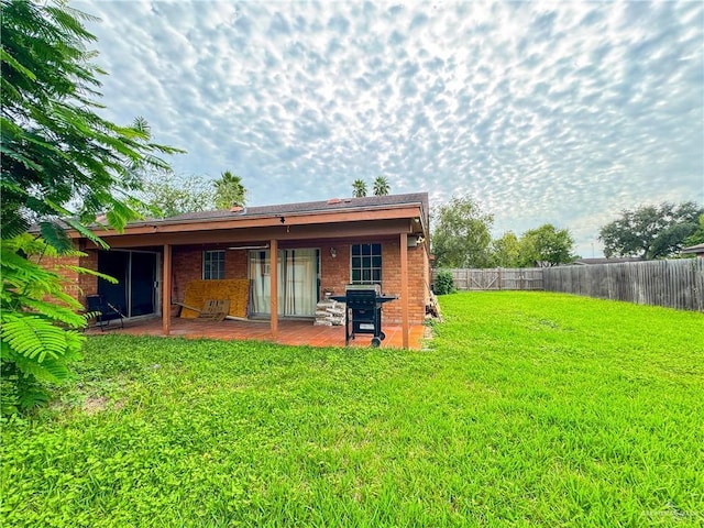 back of house with a yard and a patio