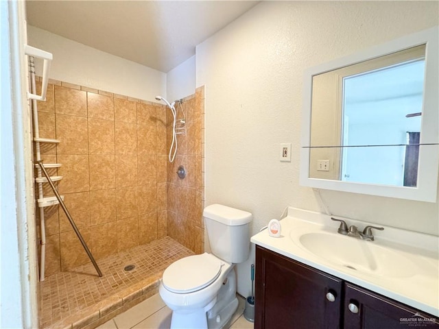 bathroom with tiled shower, vanity, and toilet