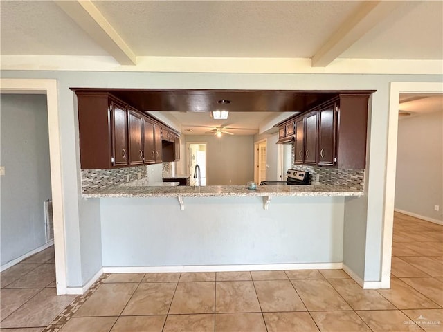 kitchen featuring stainless steel electric range, beam ceiling, kitchen peninsula, and dark brown cabinets