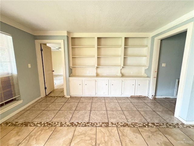 interior space featuring a textured ceiling, built in features, and light tile patterned floors