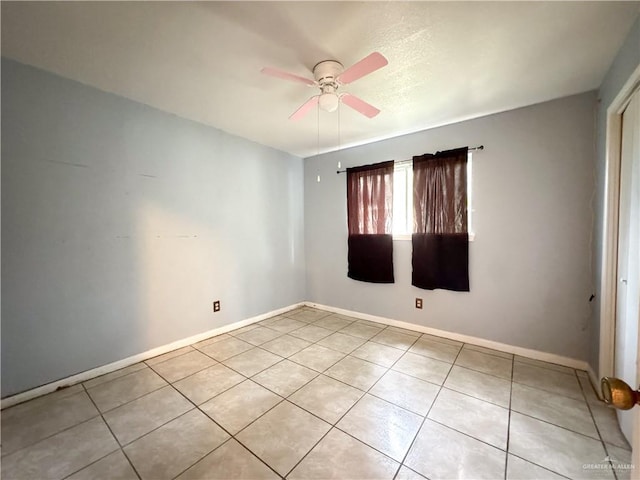 tiled spare room with ceiling fan