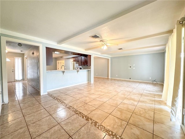 unfurnished living room with light tile patterned flooring, ceiling fan, and beam ceiling