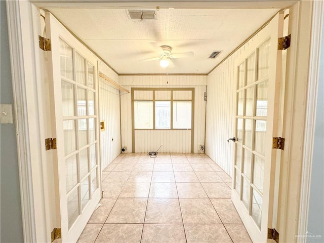 spare room featuring french doors, ceiling fan, ornamental molding, and light tile patterned flooring