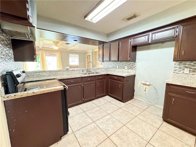 kitchen with sink, light tile patterned floors, light stone countertops, and decorative backsplash