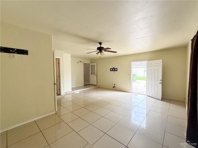 empty room with light tile patterned floors, a textured ceiling, and ceiling fan