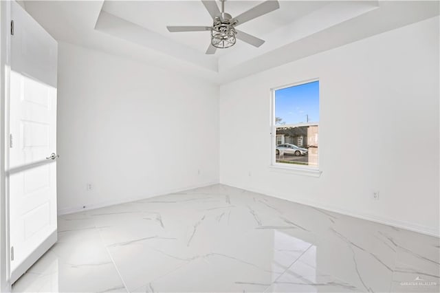 empty room with a tray ceiling and ceiling fan