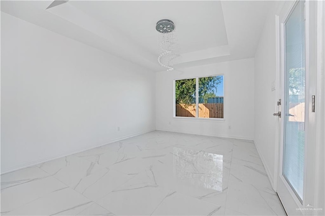 unfurnished room featuring a raised ceiling