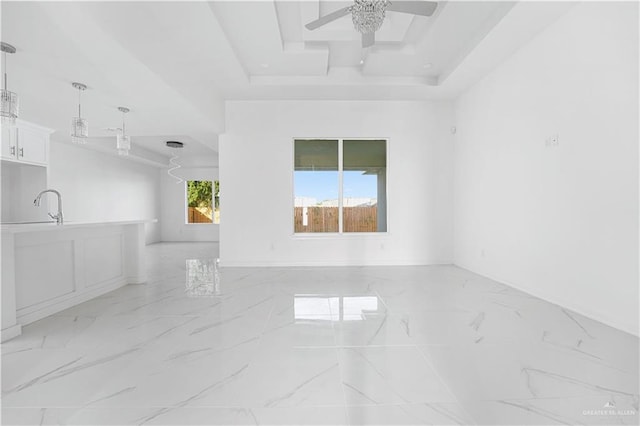 spare room featuring a tray ceiling and ceiling fan