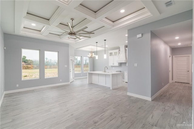 unfurnished living room with baseboards, visible vents, coffered ceiling, and ceiling fan with notable chandelier