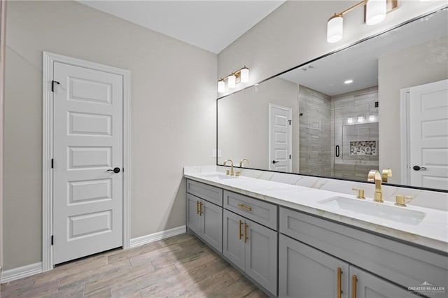 bathroom with hardwood / wood-style flooring, vanity, and walk in shower