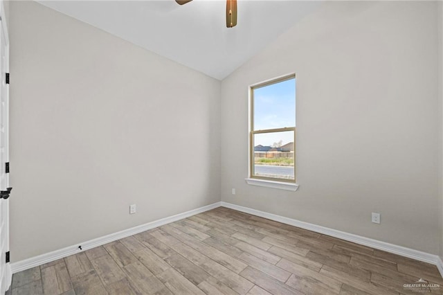 empty room with vaulted ceiling, ceiling fan, and light hardwood / wood-style floors