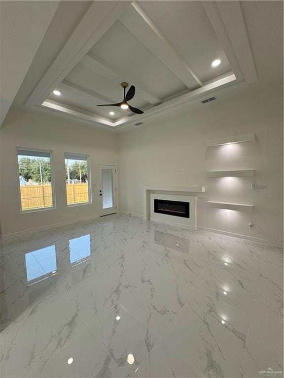 unfurnished living room with beam ceiling, a raised ceiling, and ceiling fan