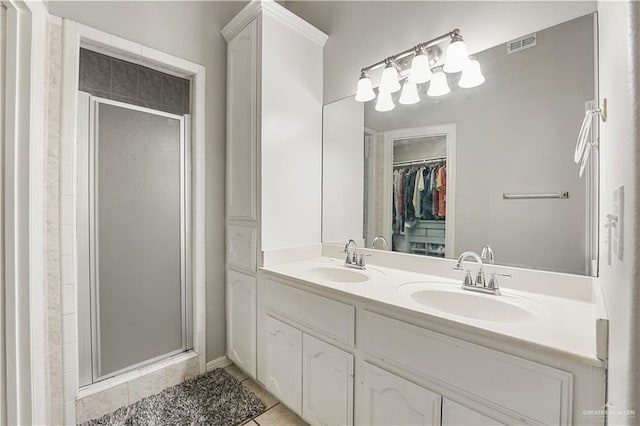 bathroom featuring a shower with door, vanity, and tile patterned flooring