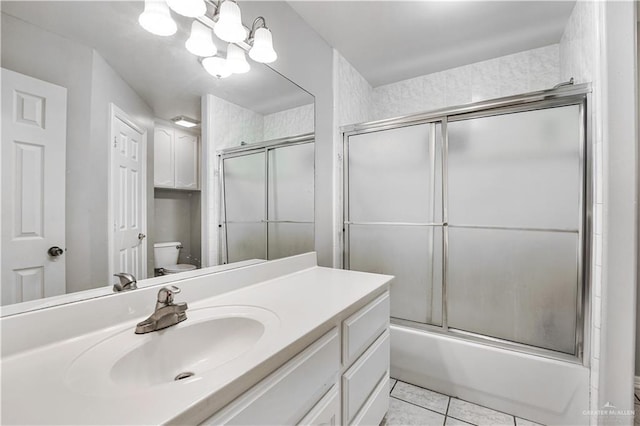 full bathroom with shower / bath combination with glass door, tile patterned flooring, an inviting chandelier, vanity, and toilet